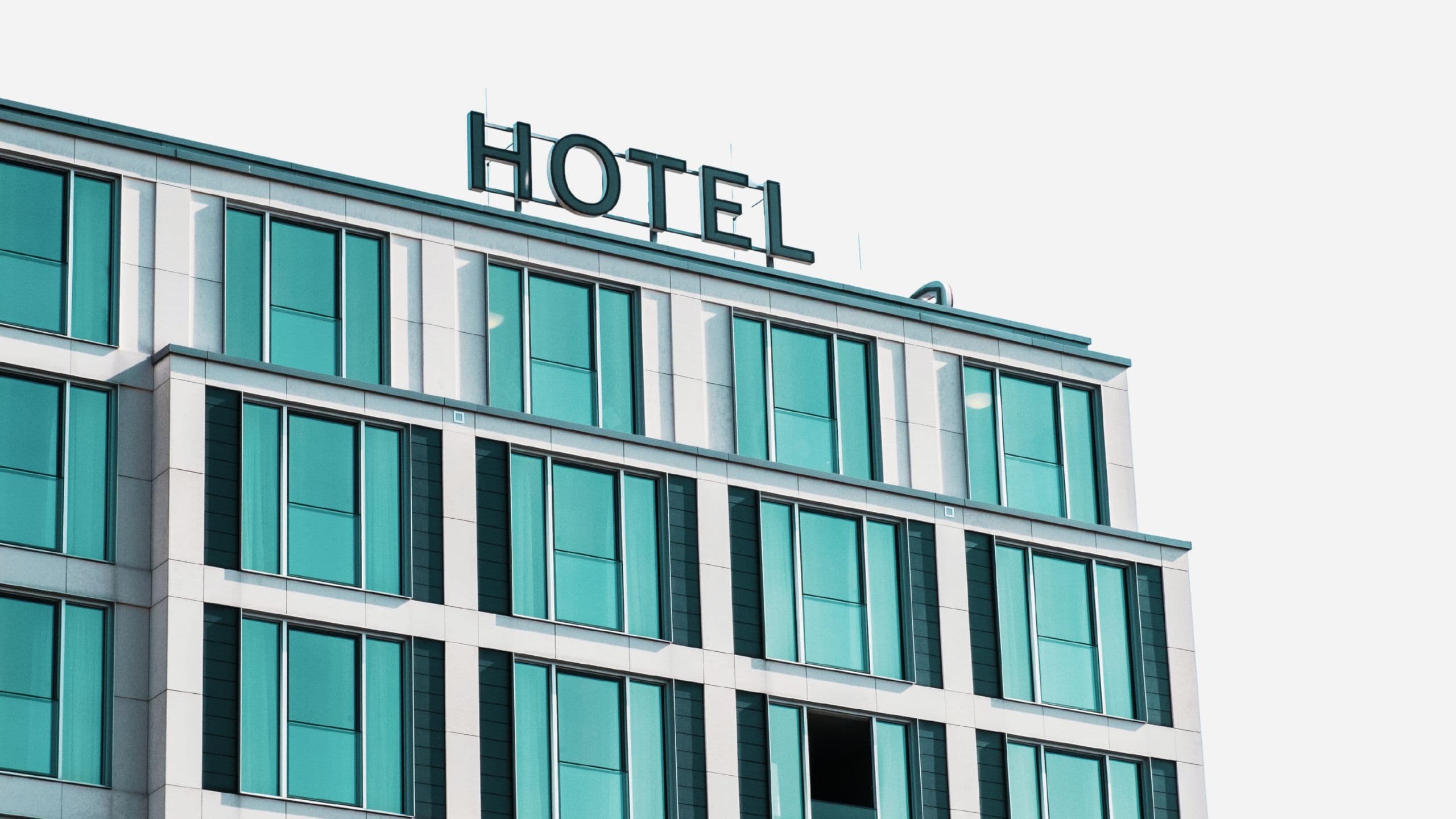 En moderne hotelbygning i Danmark, hvor man ofte kan finde rabat på hoteller, har et stort HOTEL-skilt på taget. Få rabat på hotel i Danmark som medlem af Danes Worldwide.